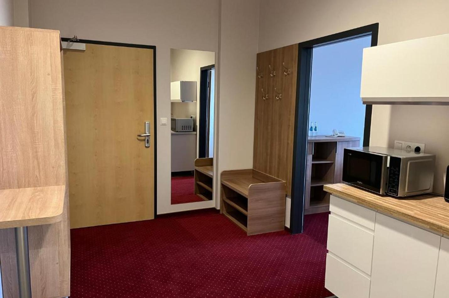 Przedsionek pokoju z aneksem kuchennym.