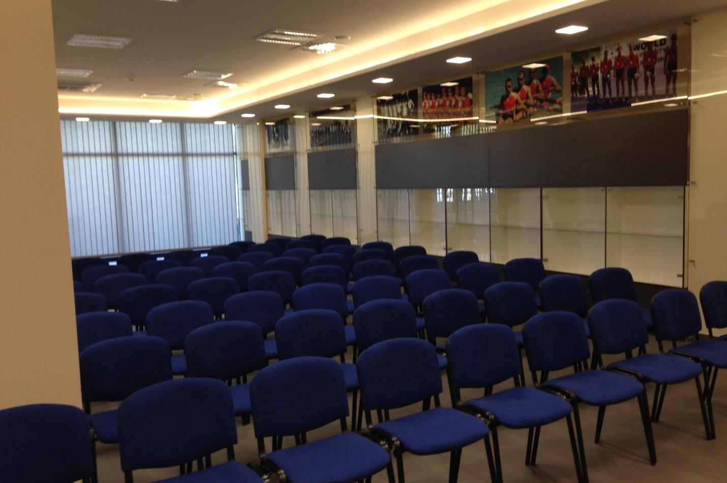 Obszerne pomieszczenie wypełnione rzędami krzeseł.