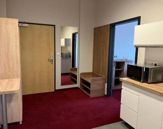 Przedsionek pokoju z aneksem kuchennym.