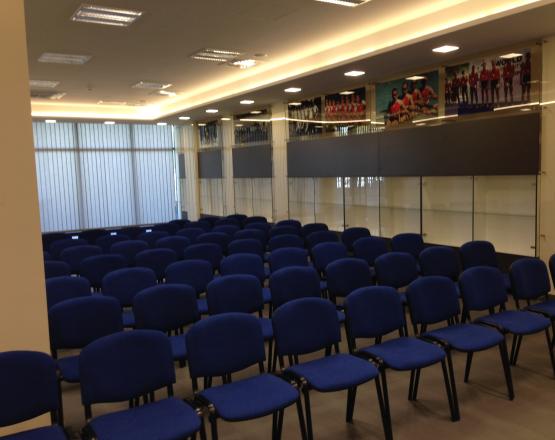 Obszerne pomieszczenie wypełnione rzędami krzeseł.