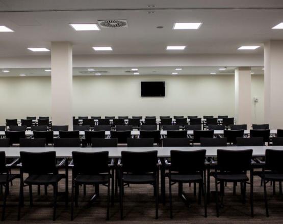 Elegancka sala konferencyjna z ustawionymi stołami i krzesłami.