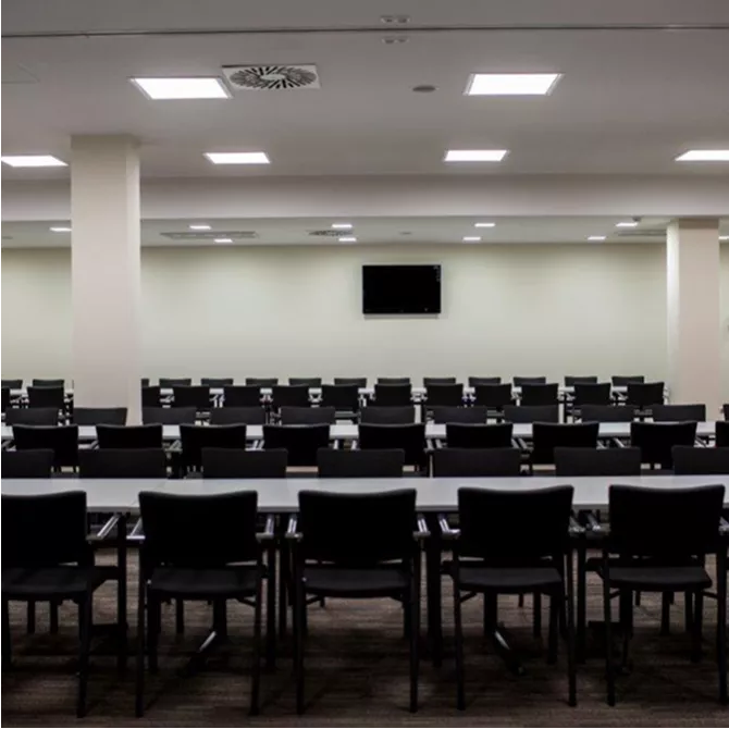 Elegancka sala konferencyjna z ustawionymi stołami i krzesłami.