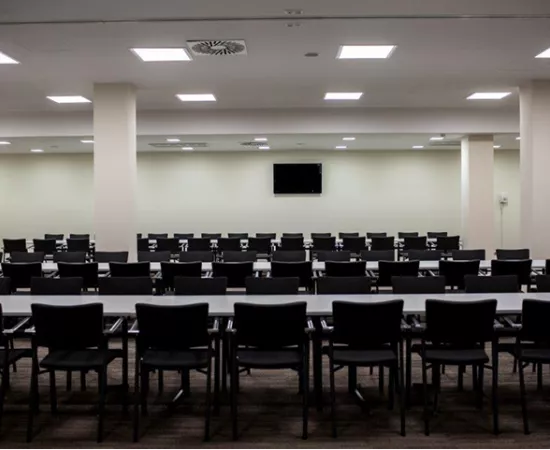 Elegancka sala konferencyjna z ustawionymi stołami i krzesłami.